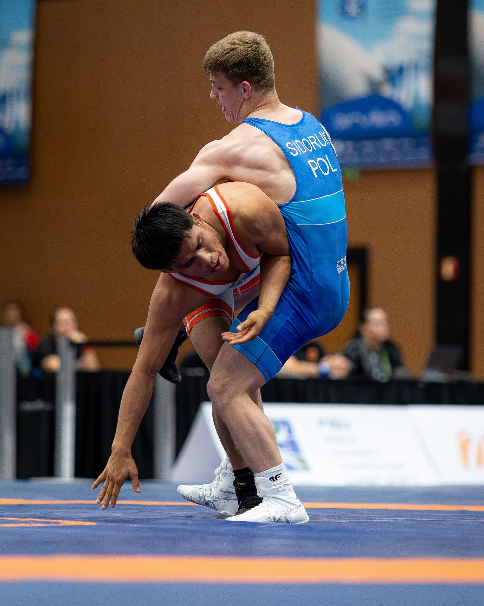 Two wrestlers mid-throw on the competition mat